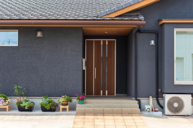 鉢植えを並べたグレーの住宅